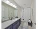 Well-lit bathroom with a sleek vanity, large mirror, and shower with curtain at 4516 Renwick Dr, Parrish, FL 34219