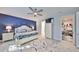 Bright bedroom boasts a striking blue accent wall, white furnishings, and a ceiling fan at 4516 Renwick Dr, Parrish, FL 34219