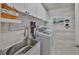 Bright laundry room featuring shiplap walls, ample storage, a sink, and modern washer and dryer at 4516 Renwick Dr, Parrish, FL 34219