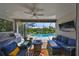 Covered patio with a full outdoor kitchen, comfortable seating, and a view of the sparkling pool at 4516 Renwick Dr, Parrish, FL 34219