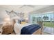 Bright bedroom with a sliding glass door to the outside and a ceiling fan at 4600 Gulf Of Mexico Dr # 202, Longboat Key, FL 34228