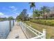 Waterfront backyard featuring a dock and lush landscaping on a sunny day at 4616 Blue Marlin Dr, Bradenton, FL 34208