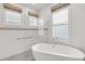 Luxurious bathroom featuring a standalone tub, tiled shower with a glass screen and plantation shutters at 4616 Blue Marlin Dr, Bradenton, FL 34208