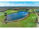 Aerial view of a serene lake, lush golf course, and a clubhouse in the distance at 4632 Benito Ct, Lakewood Ranch, FL 34211