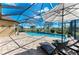 Relaxing screened pool area with brick patio, lounge chairs and umbrella overlooking the golf course at 4632 Benito Ct, Lakewood Ranch, FL 34211