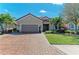 Charming home featuring a brick driveway, a two-car garage, and tropical landscaping at 4632 Benito Ct, Lakewood Ranch, FL 34211