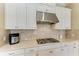 Close up on countertops and backsplash in kitchen with modern gas cooktop and stainless steel hood at 4632 Benito Ct, Lakewood Ranch, FL 34211