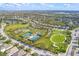 An aerial view of the community park and neighborhood featuring tennis courts, playground, walking paths, and lush landscaping at 4724 Tilden Park Ct, Bradenton, FL 34211