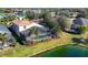 Aerial view of a home with a screened-in pool and a beautiful lake in a lush green neighborhood at 4724 Tilden Park Ct, Bradenton, FL 34211