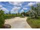 Winding concrete path in community park with benches and butterfly garden surrounded by lush green landscaping on sunny day at 4724 Tilden Park Ct, Bradenton, FL 34211