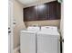 Bright laundry room with a modern washer and dryer set and ample cabinet space at 4724 Tilden Park Ct, Bradenton, FL 34211