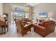 Spacious living room with high ceilings, comfortable leather furniture, and a large sliding glass door to the lanai at 4724 Tilden Park Ct, Bradenton, FL 34211