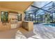 Outdoor kitchen includes stainless grill, beverage cooler, and nearby pool at 4724 Tilden Park Ct, Bradenton, FL 34211