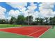 Outdoor tennis court with a red playing surface and a lush green perimeter at 4839 Turtle Bay Ter, Bradenton, FL 34203