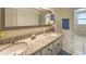 Bathroom features a dual sink vanity with granite countertop and white cabinets at 4868 Featherbed Ln, Sarasota, FL 34242