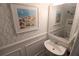 Well-decorated powder room with coastal artwork, a pedestal sink, and a charming mirror at 5072 Misty Canal Pl, Bradenton, FL 34203