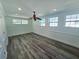 A bedroom featuring wood-look floors, three windows, white walls and trim, and a ceiling fan with overhead lighting at 611 19Th W Ave, Palmetto, FL 34221