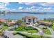 Aerial view of condo complex near the water featuring lush landscaping, parking, and community pool at 6158 Palma Del Mar S Blvd # 504, St Petersburg, FL 33715