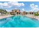 Community pool with blue water and lounge chairs surrounded by condo buildings under a cloudy sky at 6158 Palma Del Mar S Blvd # 504, St Petersburg, FL 33715