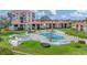Aerial view of a community pool and hot tub surrounded by lounge chairs and tropical landscape at 6158 Palma Del Mar S Blvd # 504, St Petersburg, FL 33715