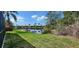 Backyard pond with tranquil water views framed by lush green grass and palm trees, creating a serene setting at 629 Sawgrass Bridge Rd, Venice, FL 34292