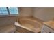 Corner soaking tub with marble surround and window in the bathroom at 629 Sawgrass Bridge Rd, Venice, FL 34292