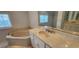 Bright bathroom with soaking tub, tiled shower, and marble countertop at 629 Sawgrass Bridge Rd, Venice, FL 34292