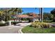 A gated community entrance with lush landscaping and an American flag at 629 Sawgrass Bridge Rd, Venice, FL 34292