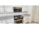 Kitchen with stainless steel oven, white cabinets and solid surface countertops at 629 Sawgrass Bridge Rd, Venice, FL 34292