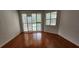 Bright living room with hardwood floors, plantation shutters, and sliding glass doors to the pool at 629 Sawgrass Bridge Rd, Venice, FL 34292