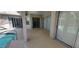 Covered patio offering a glimpse of the sparkling pool and spa, surrounded by glass doors and lush outdoor greenery at 629 Sawgrass Bridge Rd, Venice, FL 34292