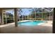 Inviting screened-in pool with a spa and a tranquil view of the pond beyond the screened enclosure at 629 Sawgrass Bridge Rd, Venice, FL 34292