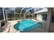 Refreshing screened-in pool with a spa and a scenic view of the trees at 629 Sawgrass Bridge Rd, Venice, FL 34292