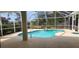 Inviting screened-in pool with a spa and a tranquil view of the pond beyond the screened enclosure at 629 Sawgrass Bridge Rd, Venice, FL 34292