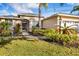 Beautiful front yard with lush landscaping, palm tree, and covered entry of this single-Gathering home at 7415 Loblolly Bay Trl, Lakewood Ranch, FL 34202