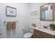 Well-lit bathroom features wood-look vanity, white shiplap walls, and coastal decor at 9 Palm Harbor Dr, Holmes Beach, FL 34217