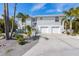 Beautiful two-story home with a two-car garage and a well-maintained front yard with tropical landscaping at 9 Palm Harbor Dr, Holmes Beach, FL 34217