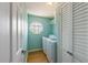 Well-lit laundry room with washer, dryer, storage shelf, and an octagonal window at 9 Palm Harbor Dr, Holmes Beach, FL 34217