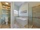 Well-lit bathroom with a soaking tub, walk-in shower, and storage shelves at 9 Palm Harbor Dr, Holmes Beach, FL 34217