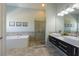 Elegant bathroom featuring a soaking tub, dual sinks, and a glass-enclosed shower at 9 Palm Harbor Dr, Holmes Beach, FL 34217