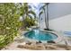 Backyard kidney-shaped pool, lounge chair, and mature palms at 9 Palm Harbor Dr, Holmes Beach, FL 34217