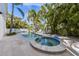 Gorgeous kidney-shaped pool and attached spa surrounded by travertine pavers at 9 Palm Harbor Dr, Holmes Beach, FL 34217