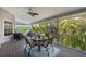 Relaxing screened porch with comfortable seating and views of lush tropical greenery at 9 Palm Harbor Dr, Holmes Beach, FL 34217