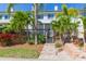 Backyard of a townhouse with a deck, lush greenery, and a paved walkway at 903 Pinellas Bayway S # 102, St Petersburg, FL 33715