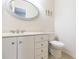 Bathroom showcasing a white vanity, an oval mirror, and a toilet at 903 Pinellas Bayway S # 102, St Petersburg, FL 33715