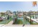Boat dock showcasing boats on lifts in a waterfront setting with houses in the background at 903 Pinellas Bayway S # 102, St Petersburg, FL 33715