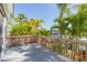Deck with wood railing overlooking a serene waterfront with lush tropical vegetation at 903 Pinellas Bayway S # 102, St Petersburg, FL 33715