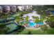 Aerial view of the community pool and clubhouse surrounded by lush greenery and palm trees, creating a resort-like atmosphere at 9998 Key Haven Rd, Seminole, FL 33777