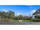 Clubhouse exterior featuring a well-manicured lawn, palm trees, and an American flag, creating a welcoming and inviting atmosphere at 9998 Key Haven Rd, Seminole, FL 33777