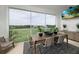 A dining area with a wooden table, stylish seating, decorative plants, and a beautiful view of the surrounding nature at 9998 Key Haven Rd, Seminole, FL 33777